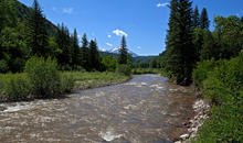 Spring river with snow peaked mountains in background