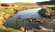Colorado stream with headgate in the foreground. 