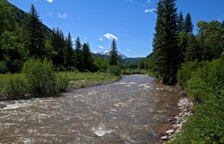 Spring river with snow peaked mountains in background